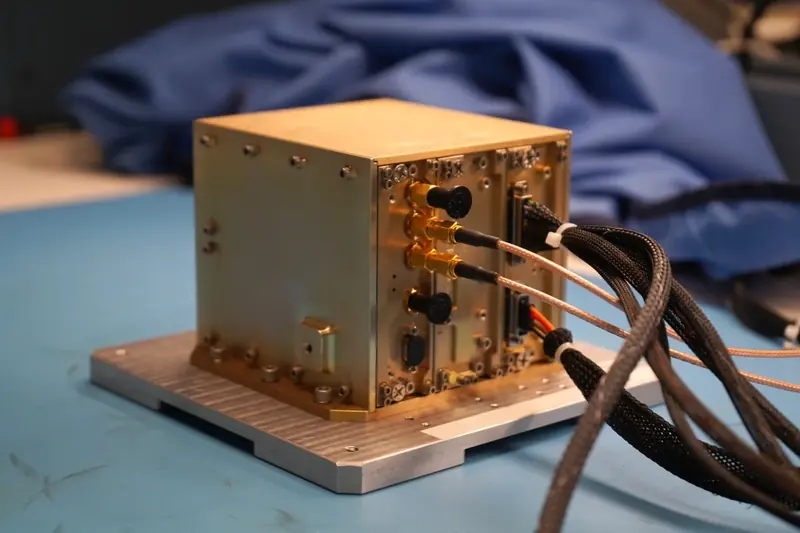 Gold-colored NavCube3-mini navigation hardware on a laboratory bench